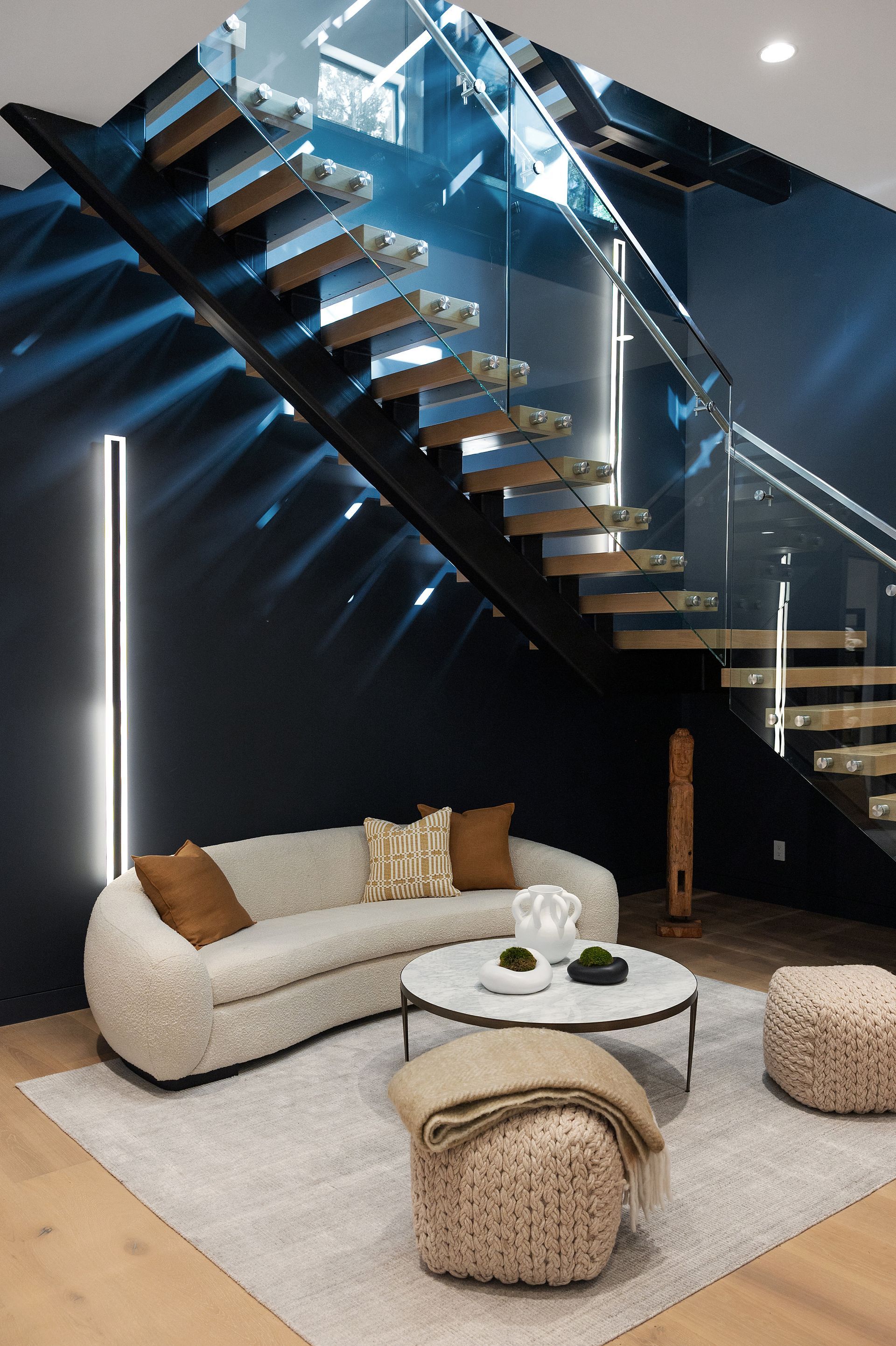 A living room with a couch , coffee table and stairs.