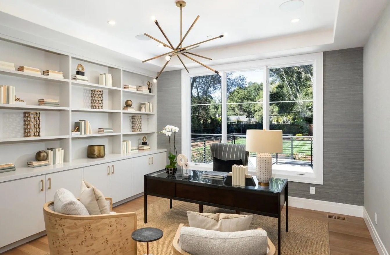 A home office with a desk , chair , and shelves.