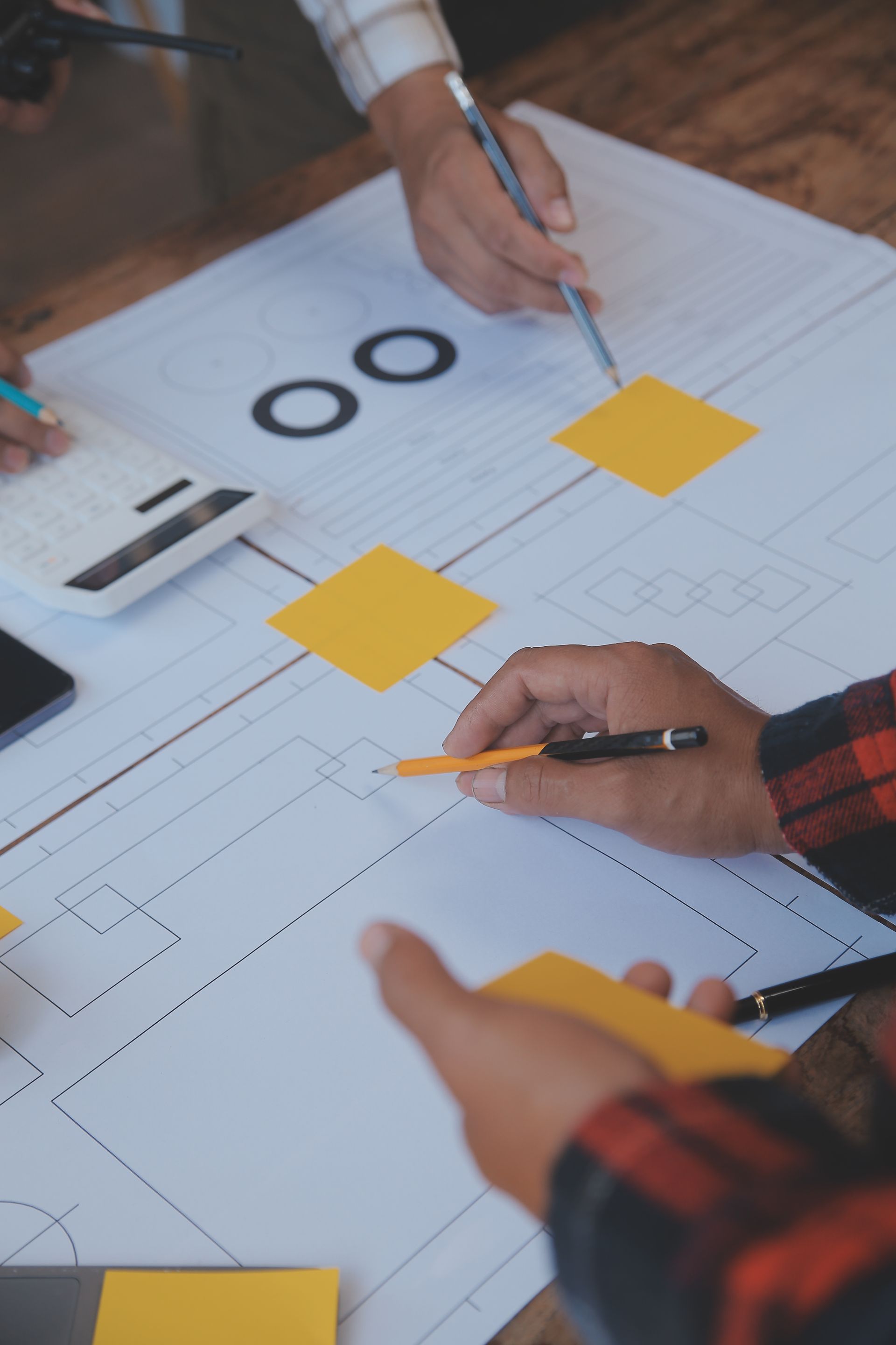 A group of people are sitting at a table working on a blueprint.