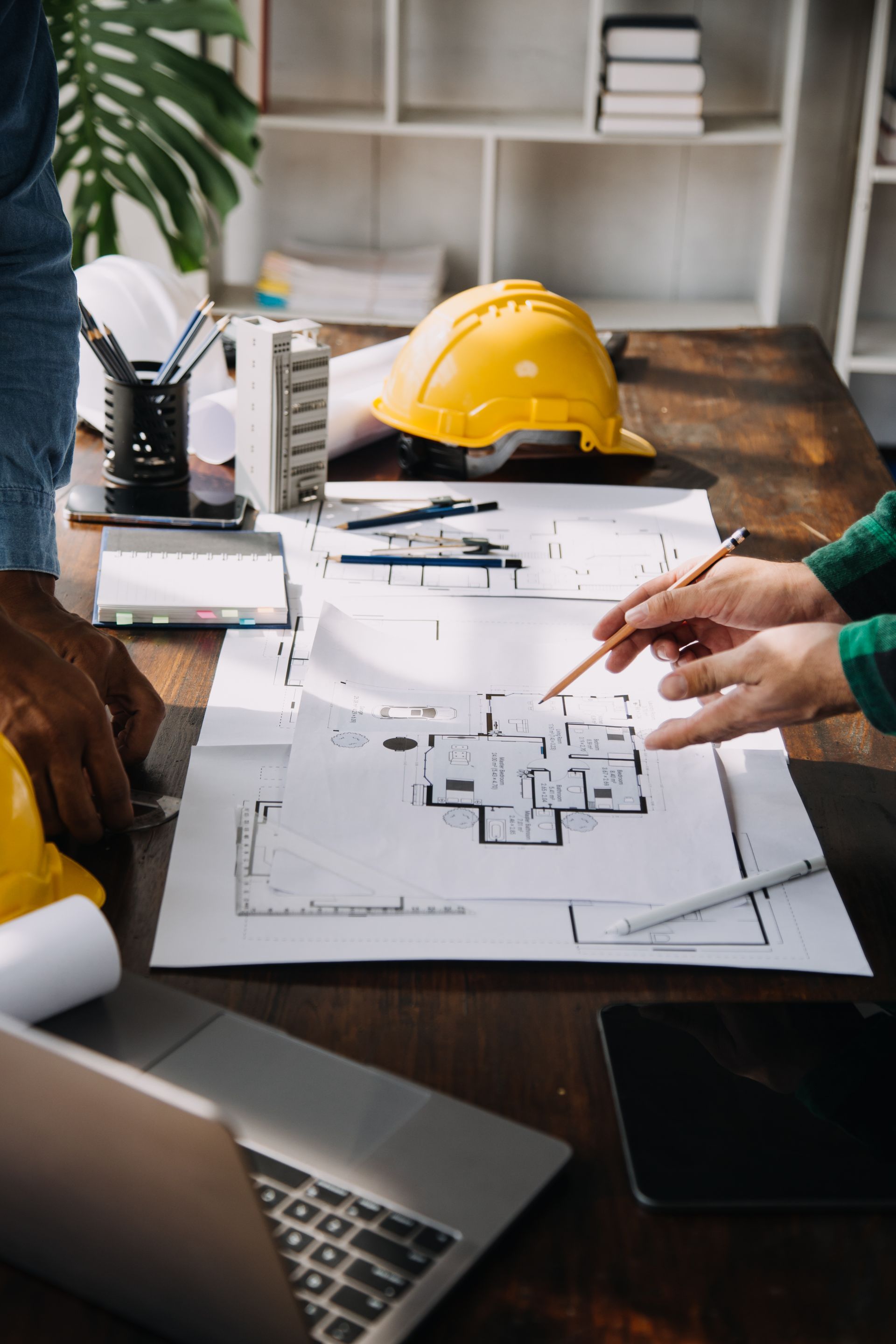 A group of people are sitting at a table looking at a blueprint.