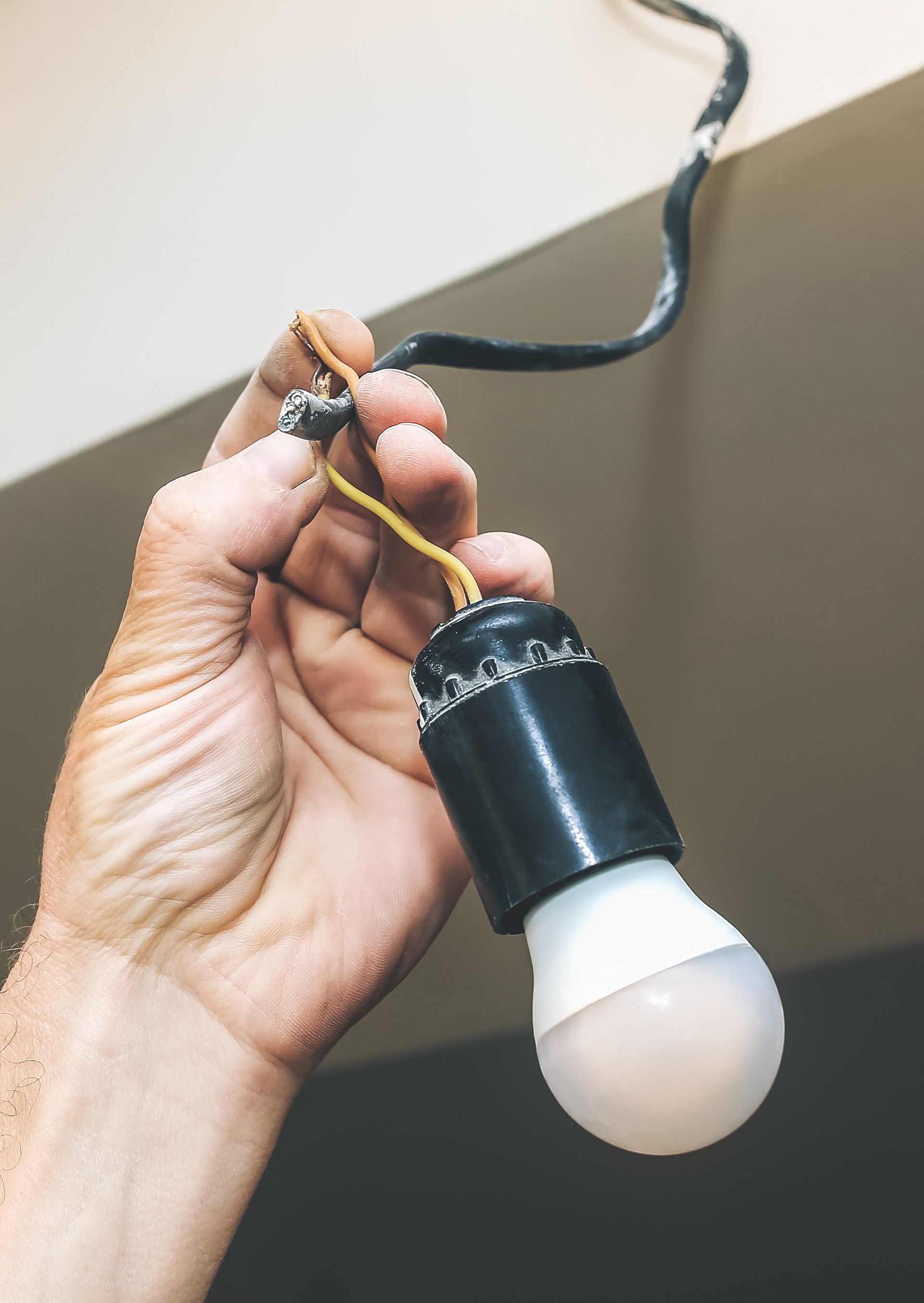 A person is holding a light bulb in their hand