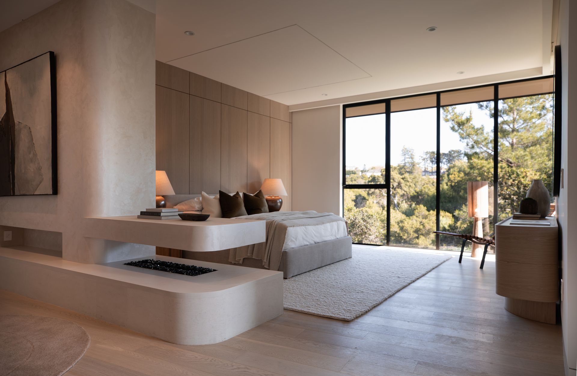 A bedroom with a fireplace and a large window.