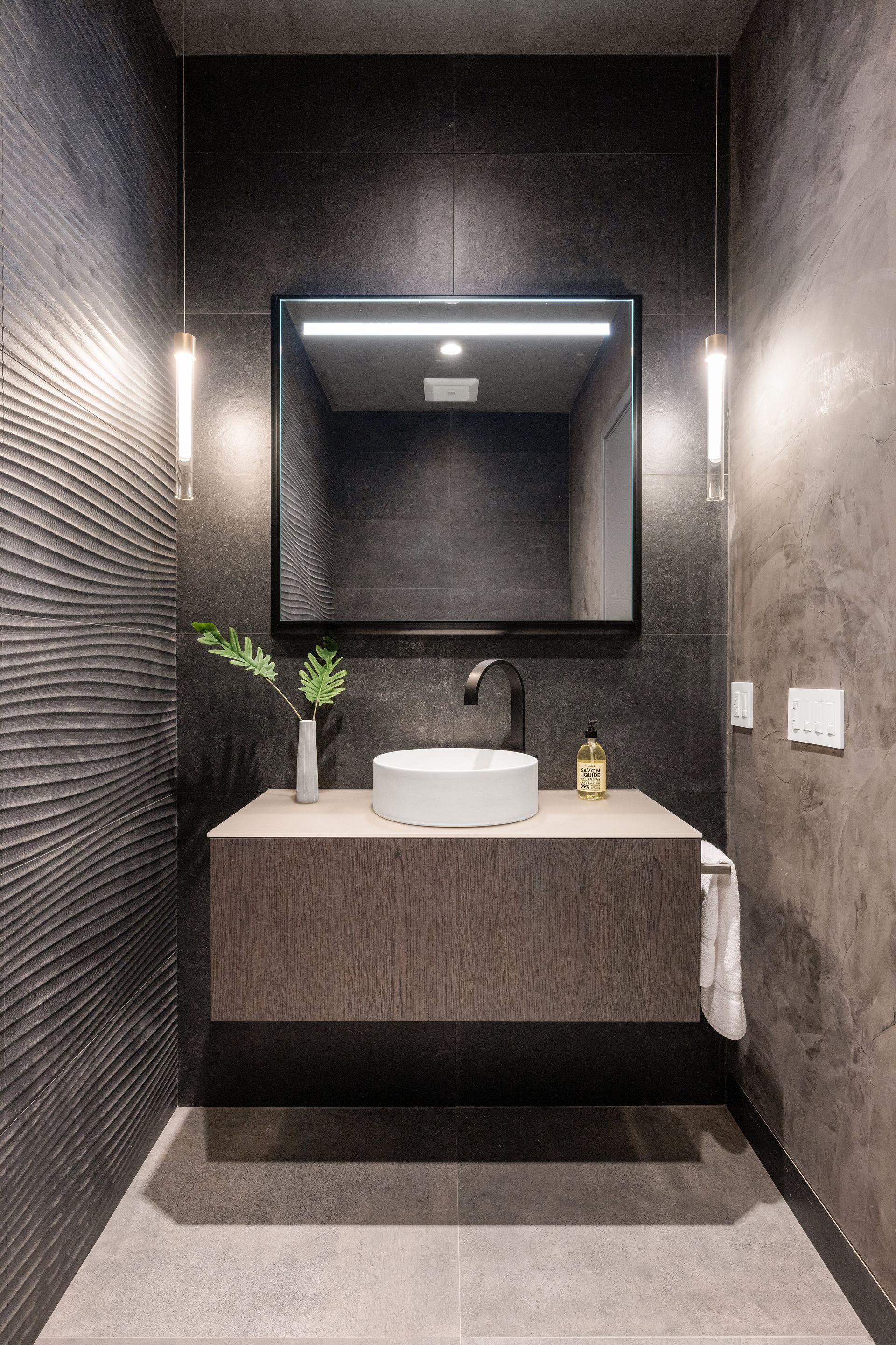 A bathroom with a sink , mirror , and towel rack.