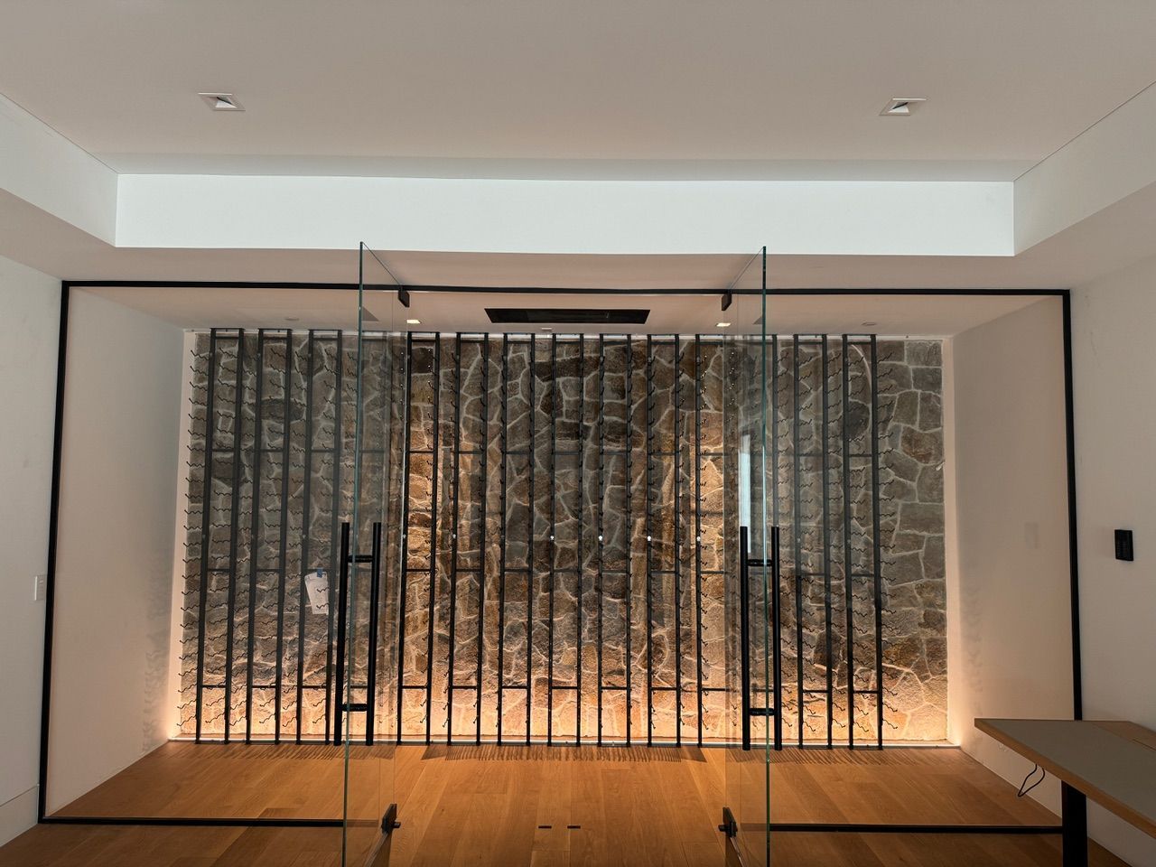 A room with a sliding glass door and a brick wall behind it.