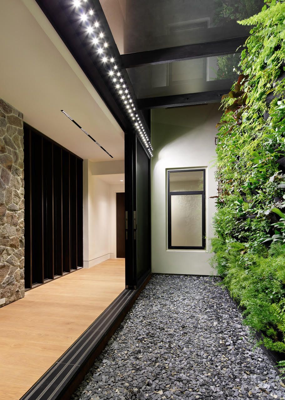 A hallway with a green wall and a window