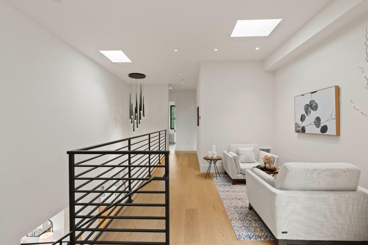 A living room with a couch and chairs and a railing.
