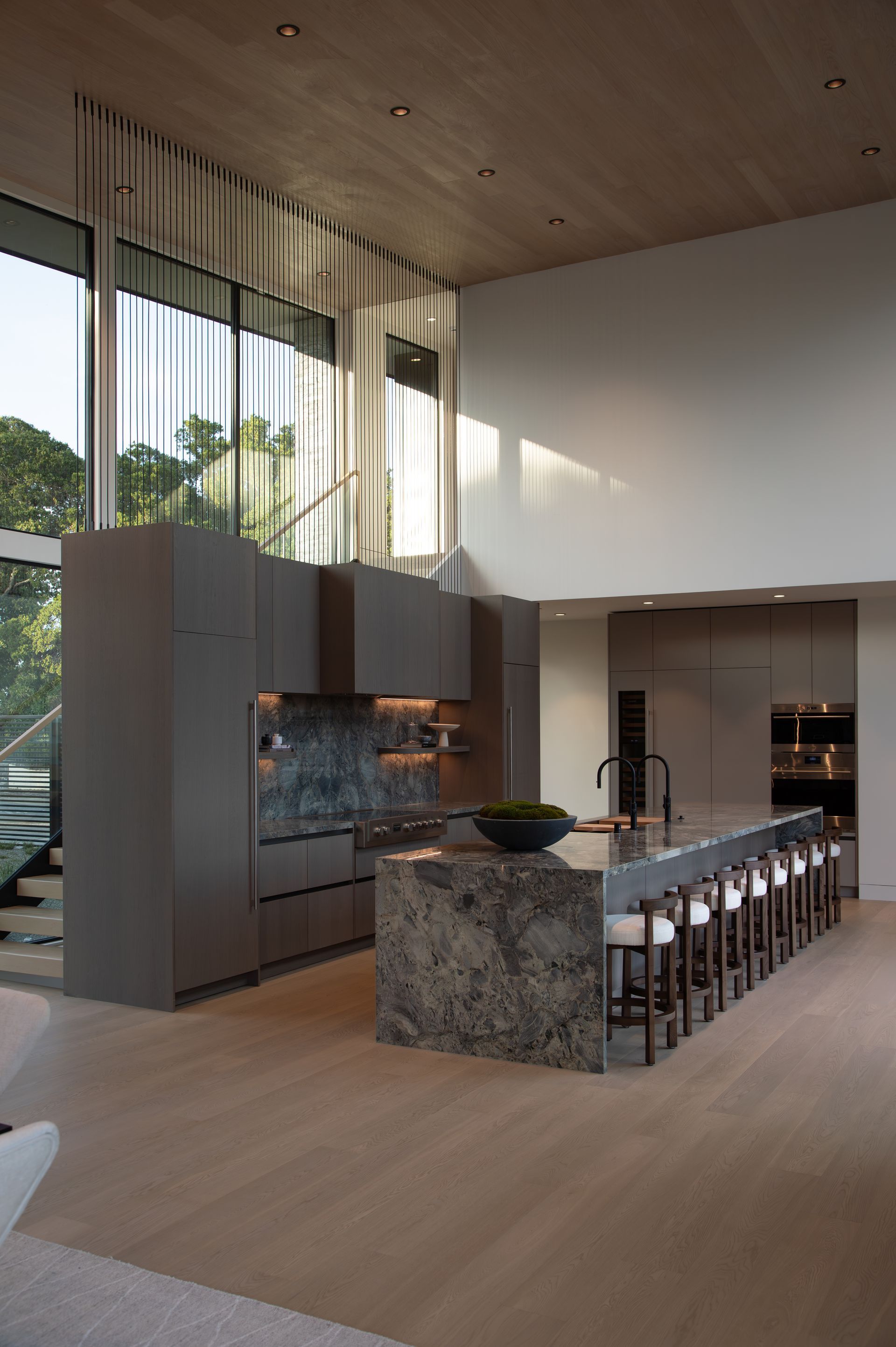 A kitchen with a large island and a lot of windows.