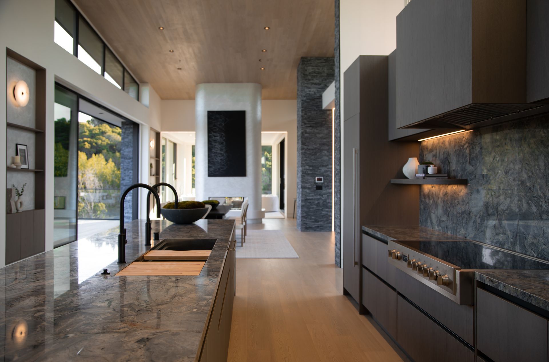 A kitchen with a large island , sink , stove and refrigerator.