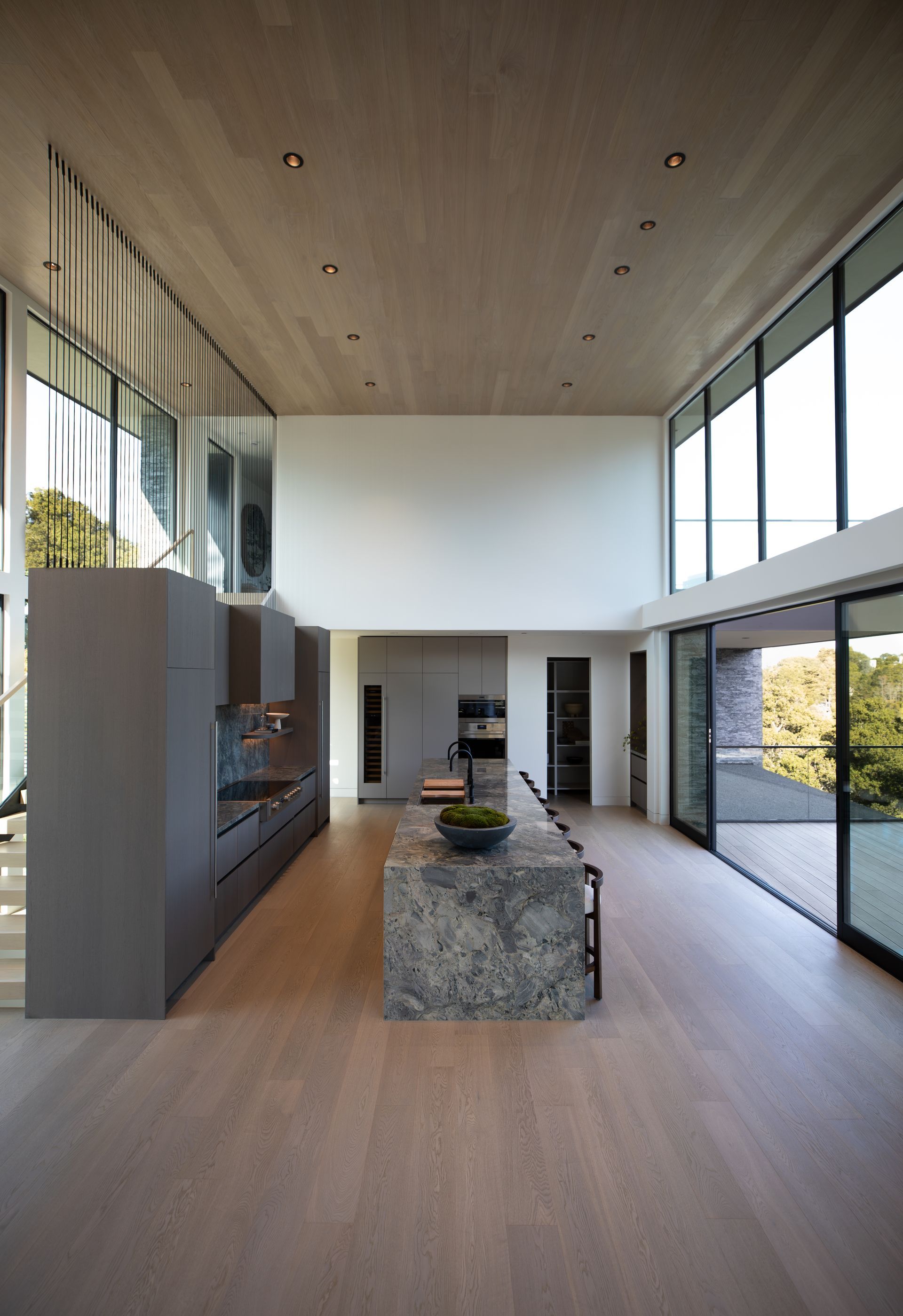 A kitchen with a large island and lots of windows