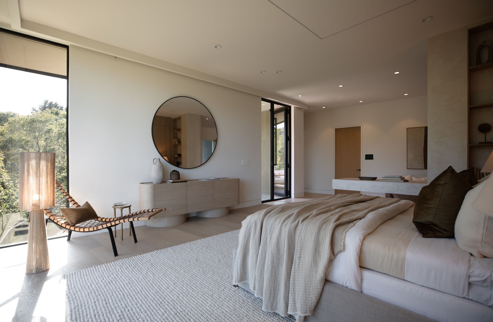 A bedroom with a large bed , chair , and mirror.