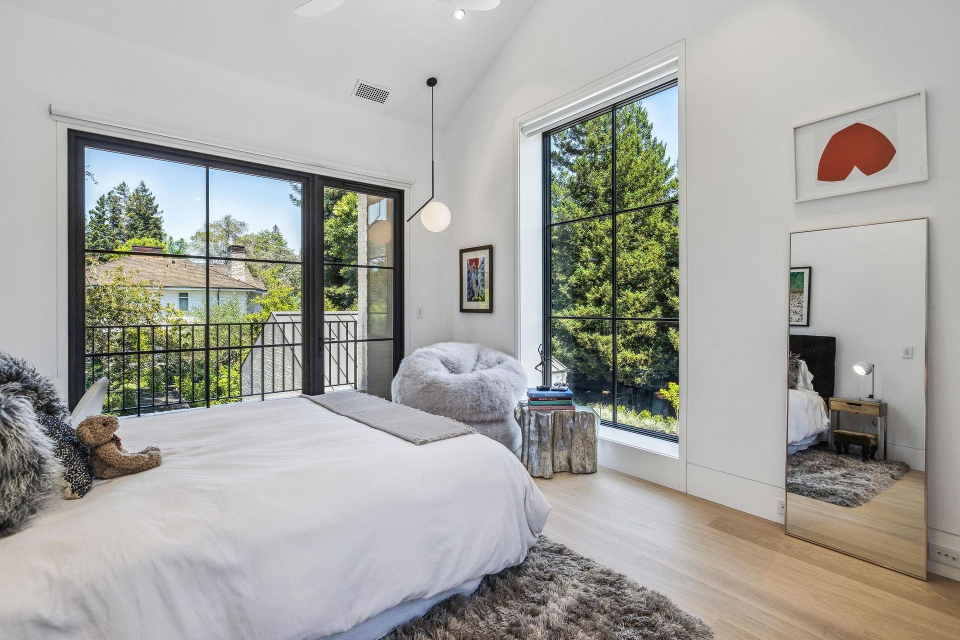 A bedroom with a large bed and a large mirror.