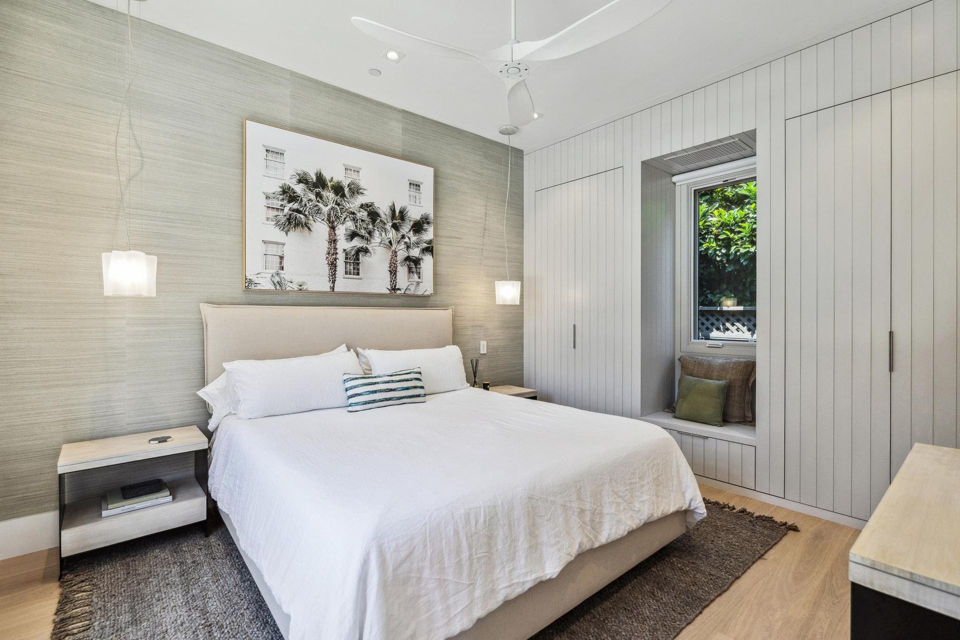 A bedroom with a large bed and a window seat.