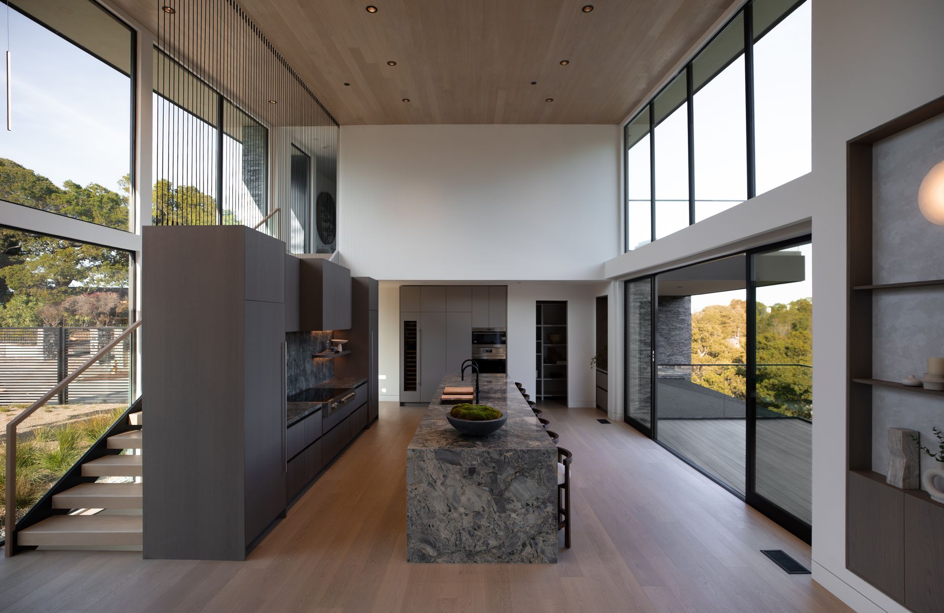 A kitchen with a large island and lots of windows
