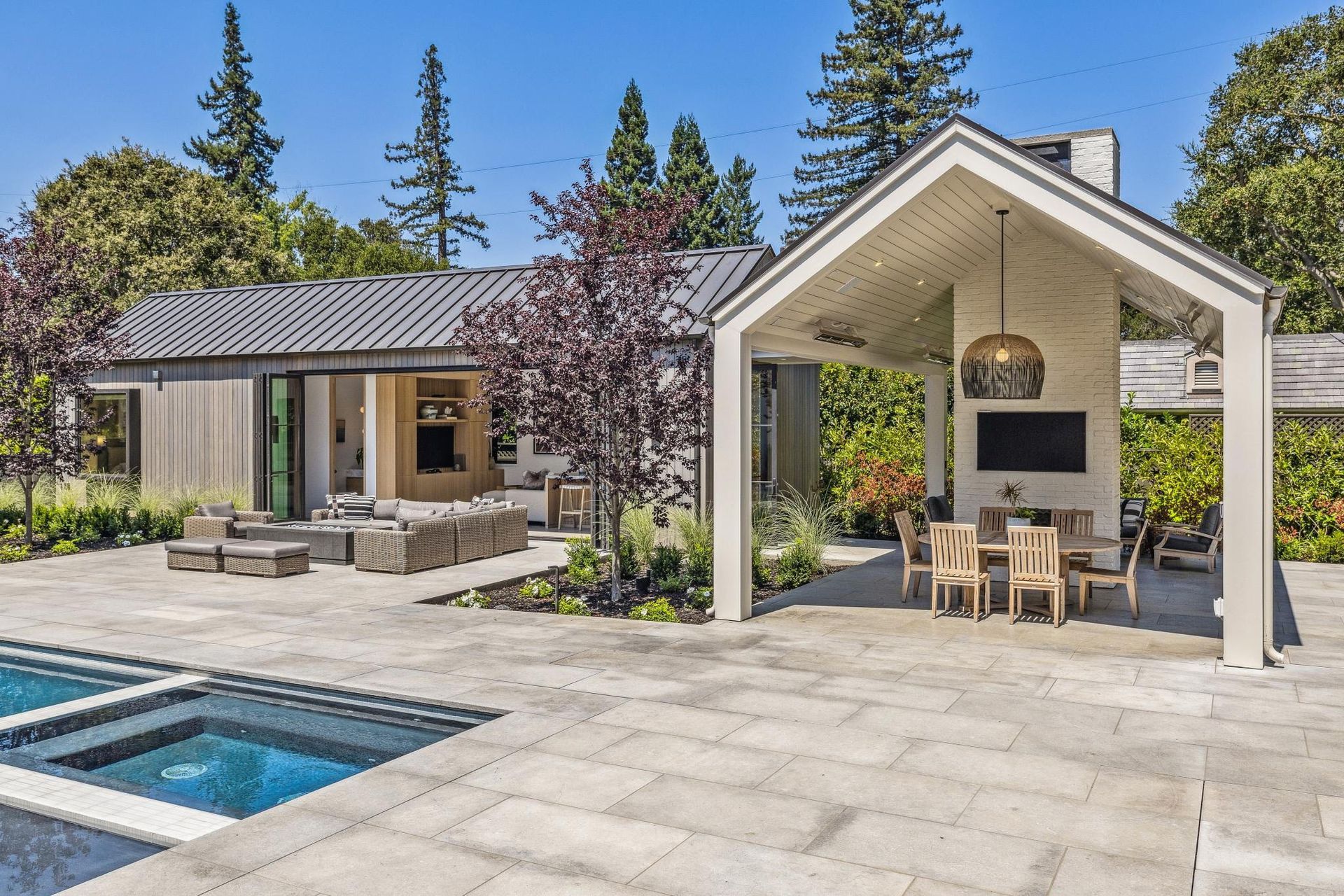 A house with a swimming pool and a table and chairs in front of it.