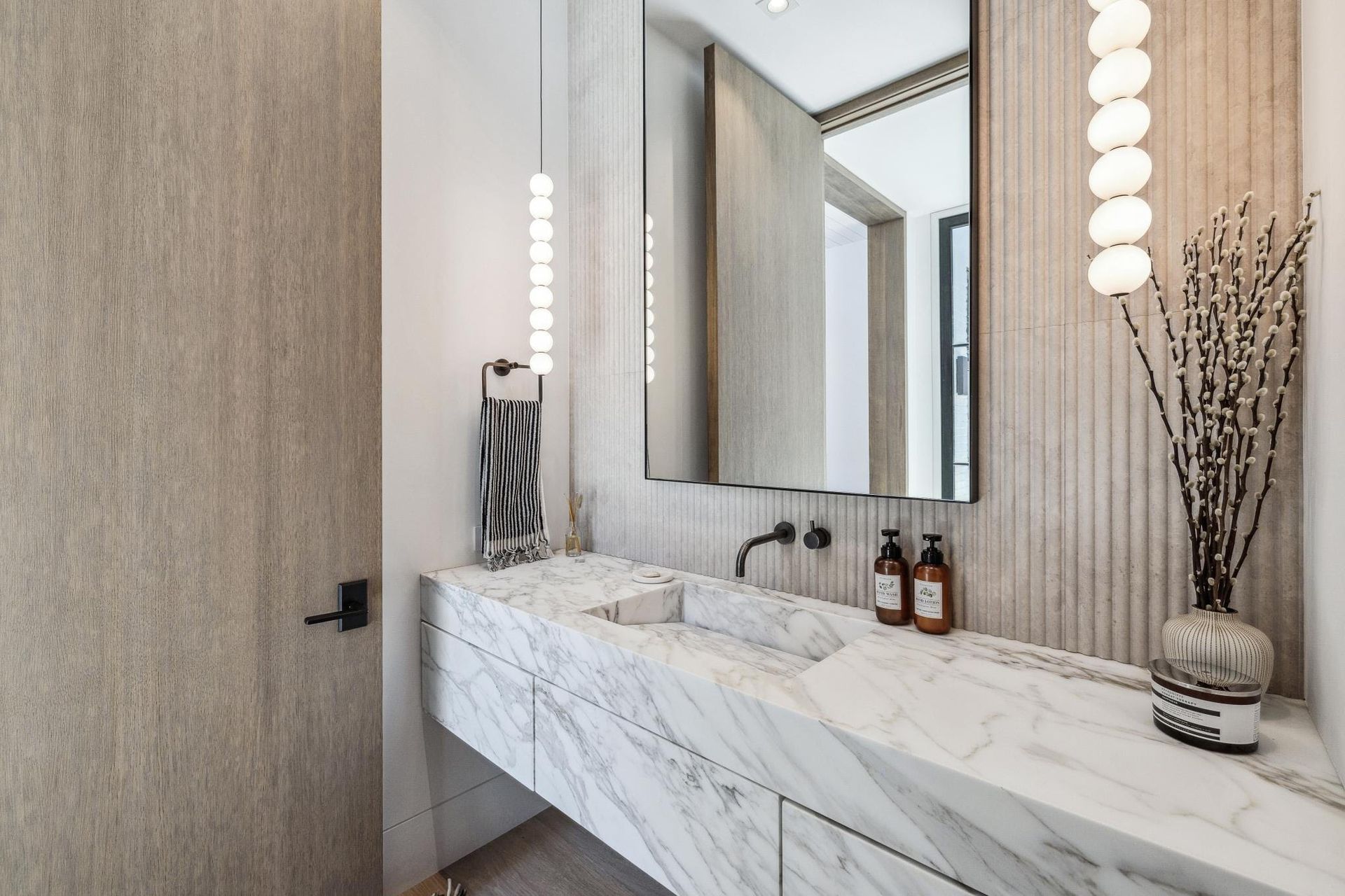 A bathroom with a marble counter top , sink and mirror.