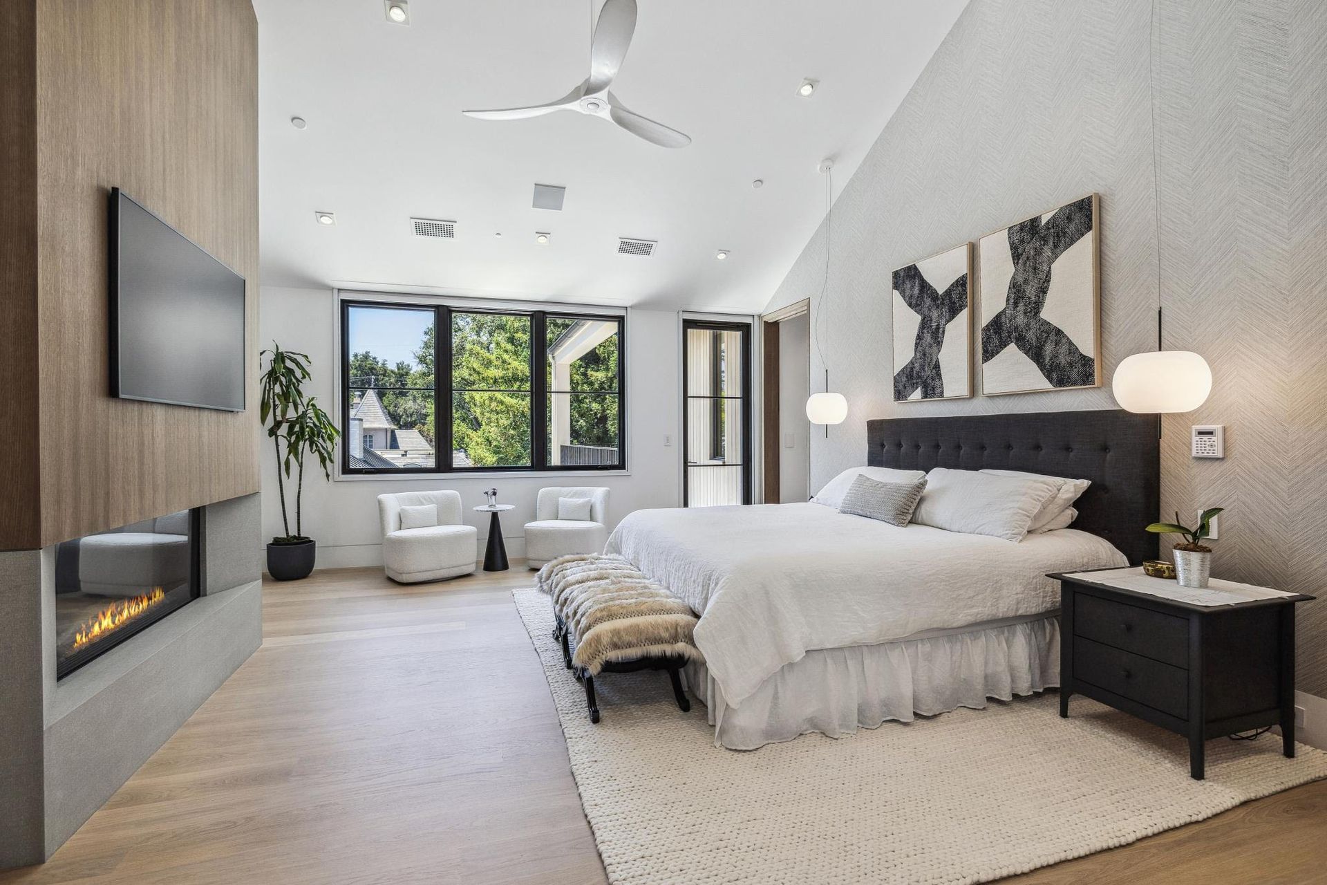 A bedroom with a large bed , fireplace and television.
