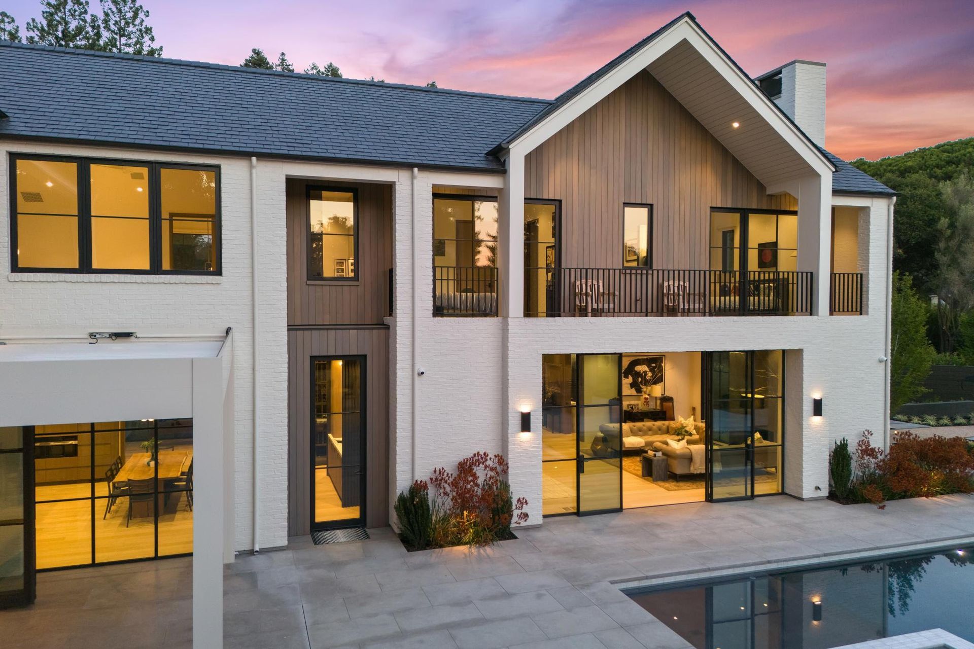 A large white house with a swimming pool in front of it.