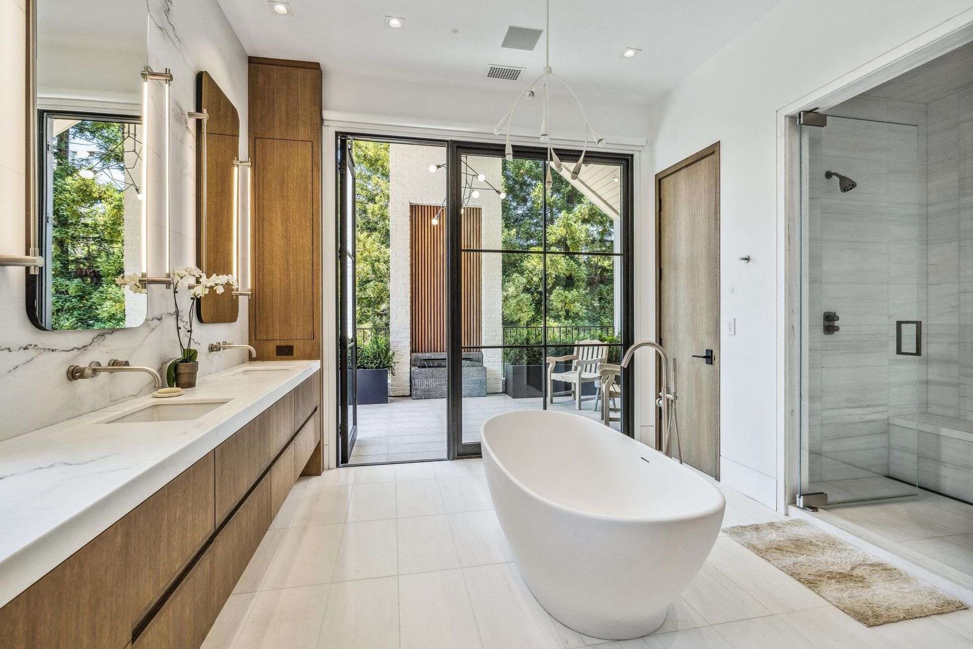 A bathroom with a bathtub , sinks , mirrors and sliding glass doors.