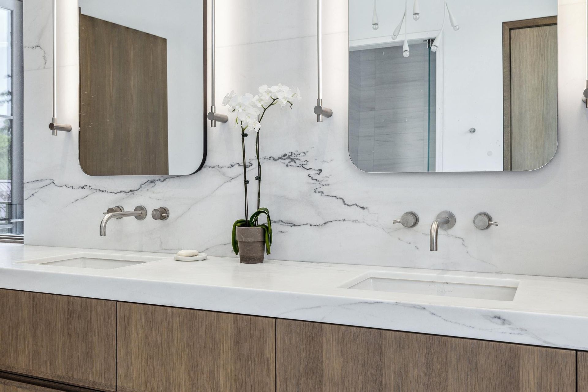 A bathroom with two sinks and two mirrors.