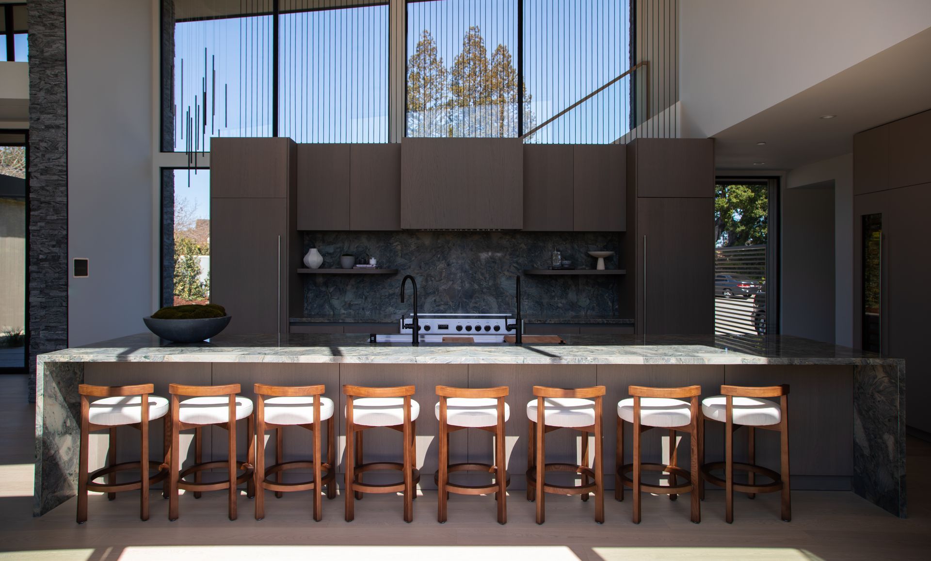 A kitchen with a long island and stools