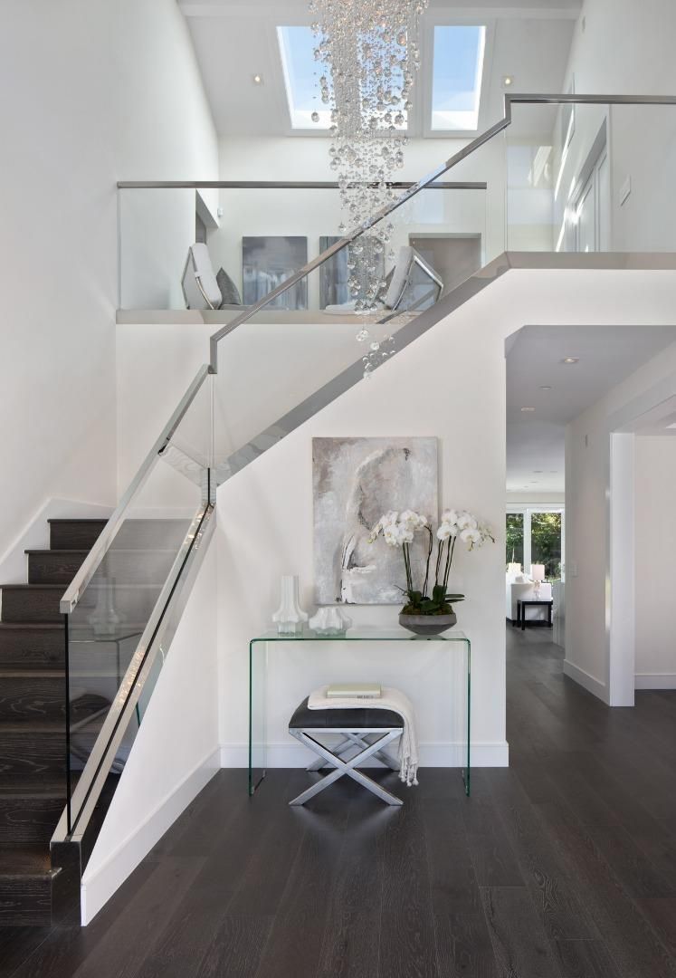 A staircase with a glass railing leading up to the second floor