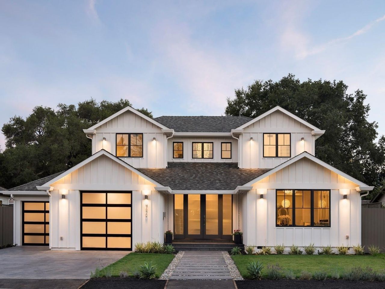 A large white house with a black garage door