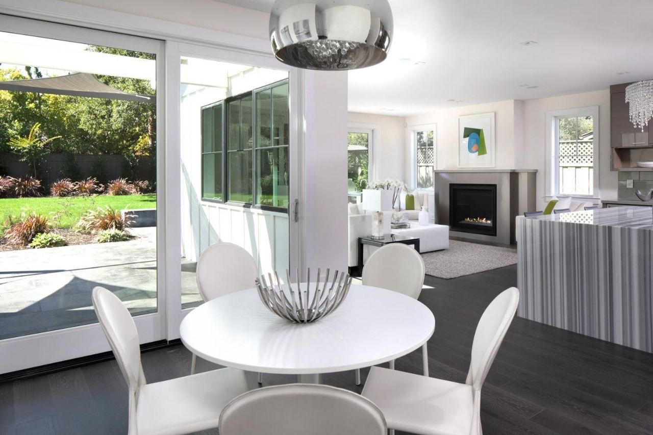 A dining room with a round table and white chairs