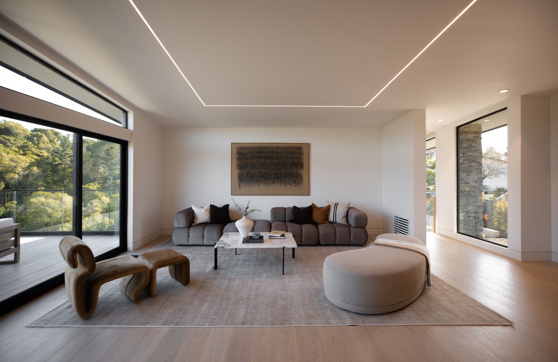 A living room with a couch , chair , coffee table and ottoman.
