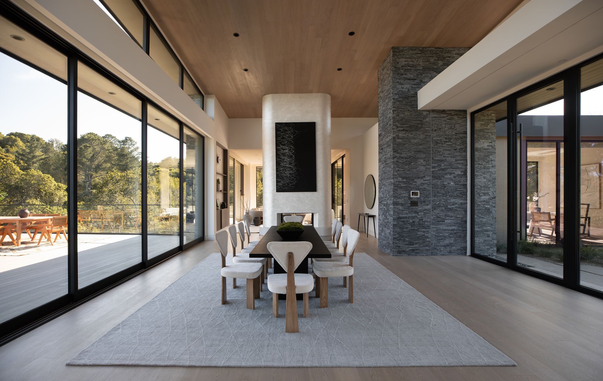 A dining room with a table and chairs and lots of windows