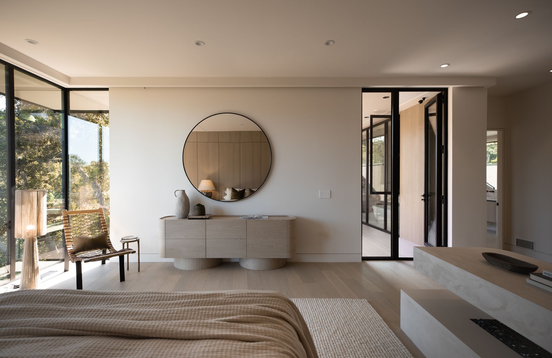 A bedroom with a large round mirror on the wall