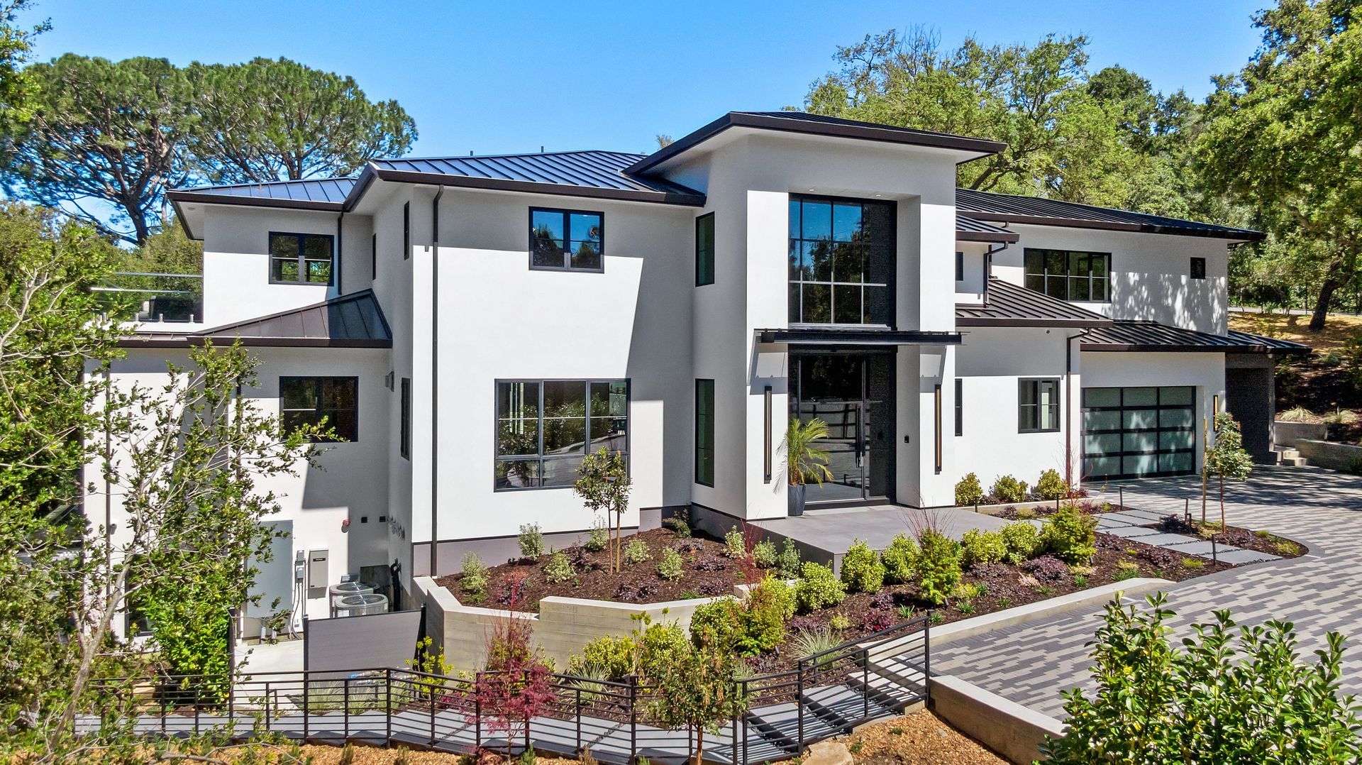 A large white house with a lot of windows is surrounded by trees.