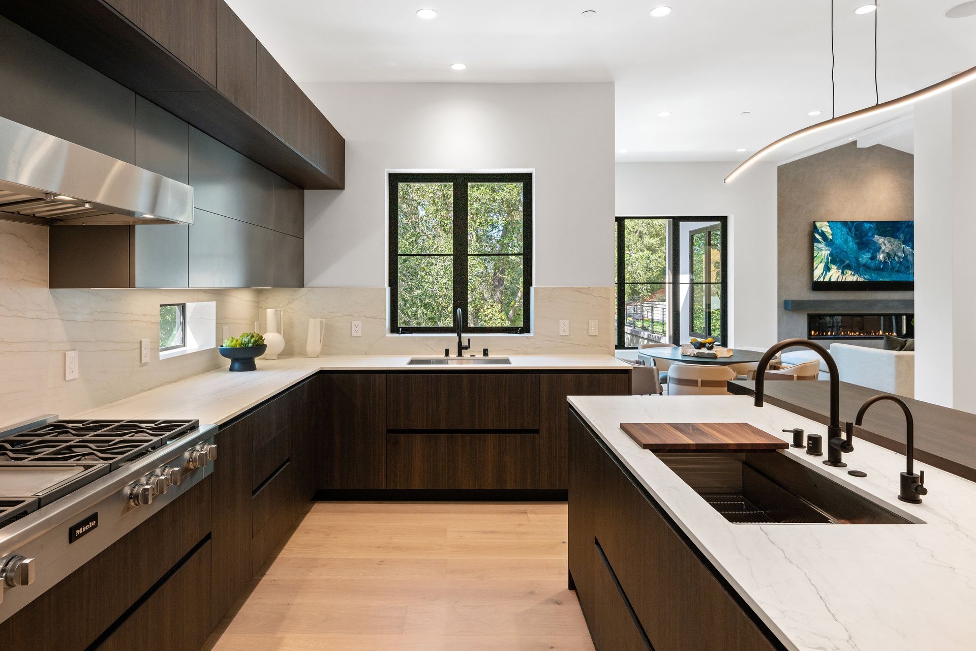 A kitchen with stainless steel appliances , wooden cabinets , a sink and a stove.