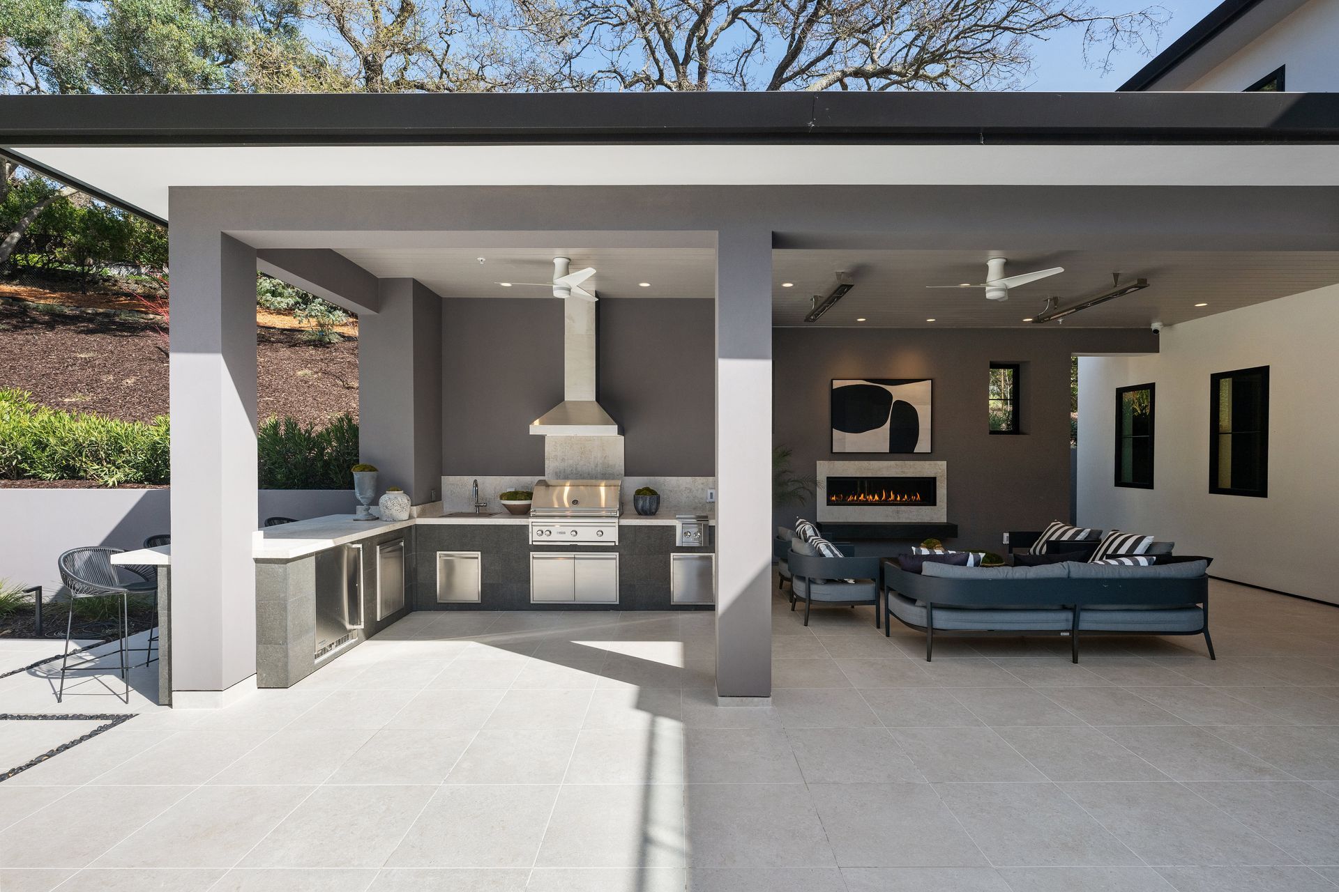 A large covered patio with a kitchen and a fireplace