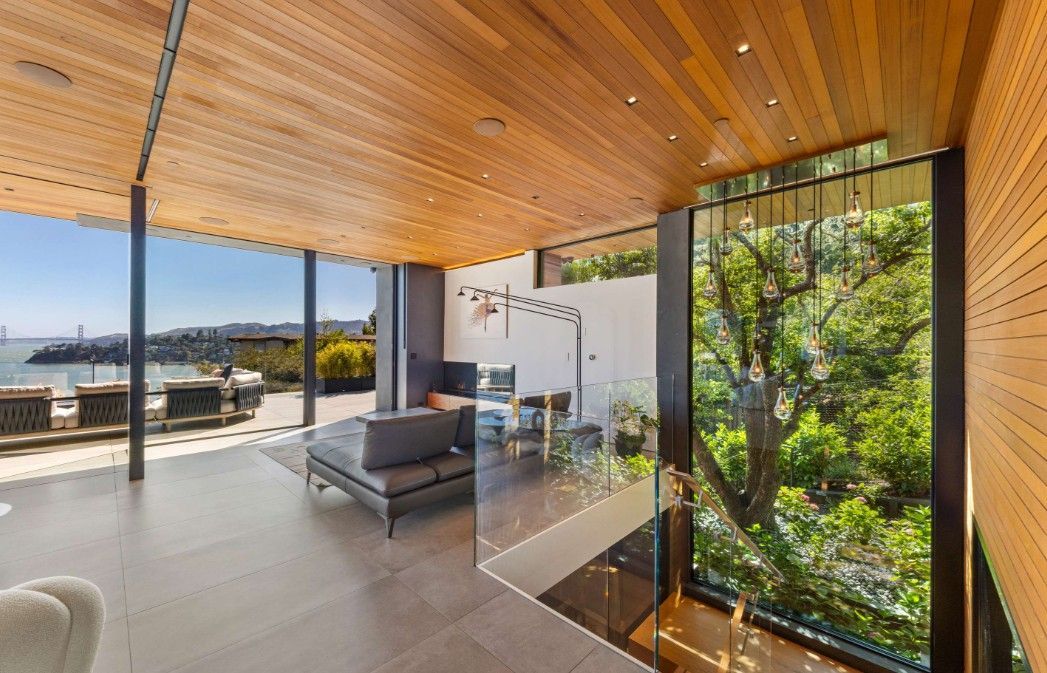 A living room with a lot of windows and a wooden ceiling.