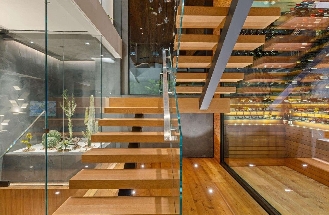 A wooden staircase with a glass railing in a house