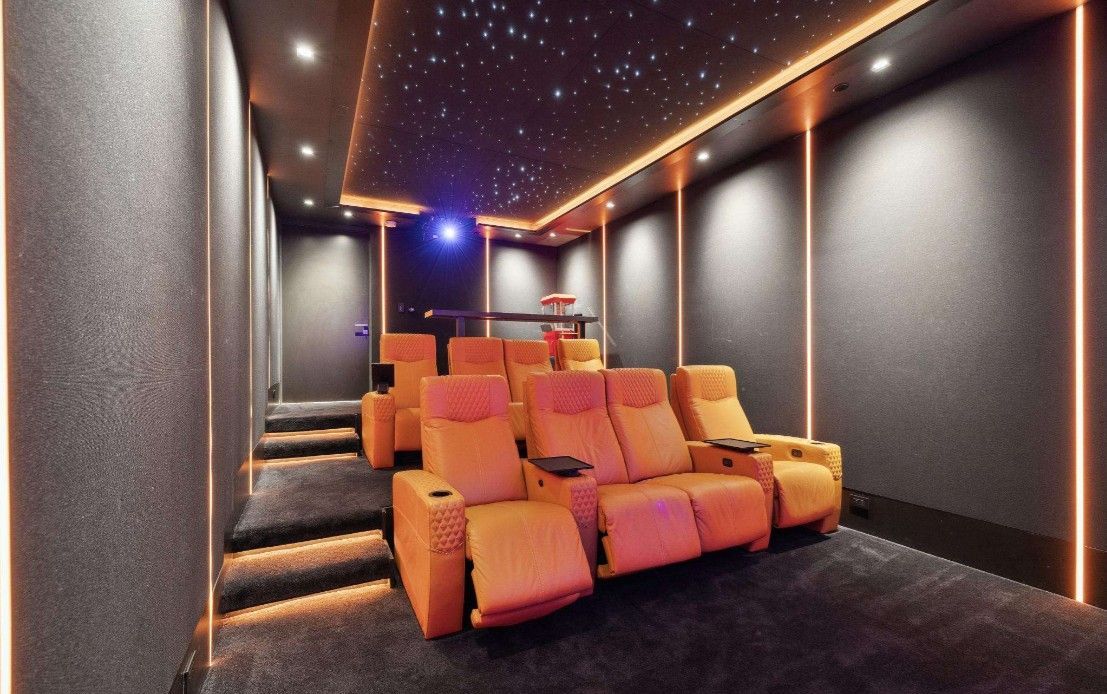 A home theater with orange seats and a starry ceiling.