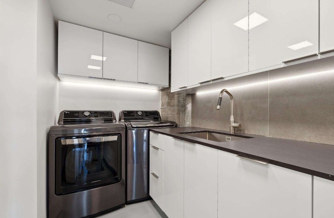 A kitchen with stainless steel appliances and white cabinets.