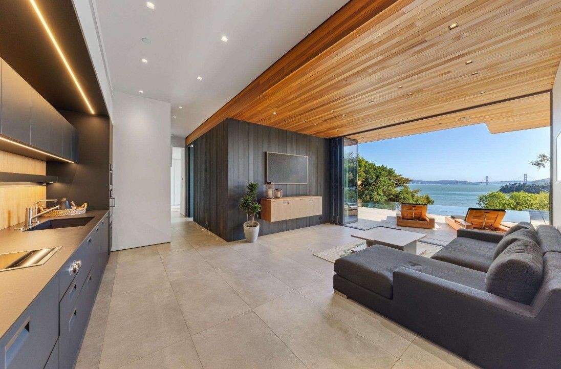 A living room with a couch and a view of the ocean.