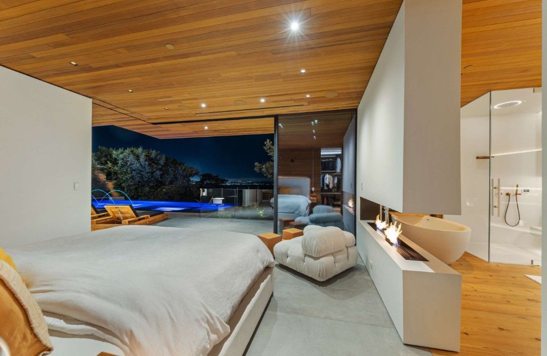 A bedroom with a large bed and a fireplace.