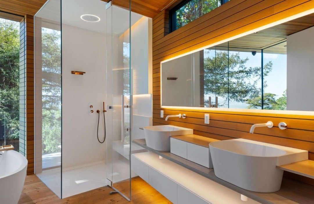A bathroom with two sinks and a walk in shower.