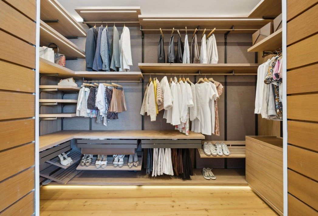A walk in closet filled with clothes and shoes.