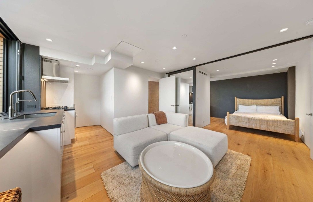 A living room with a couch , table , and bed.