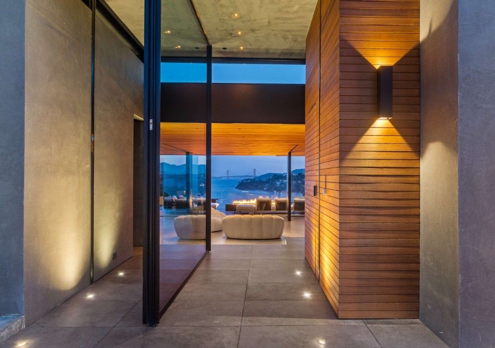 A hallway leading to a living room with a view of the ocean