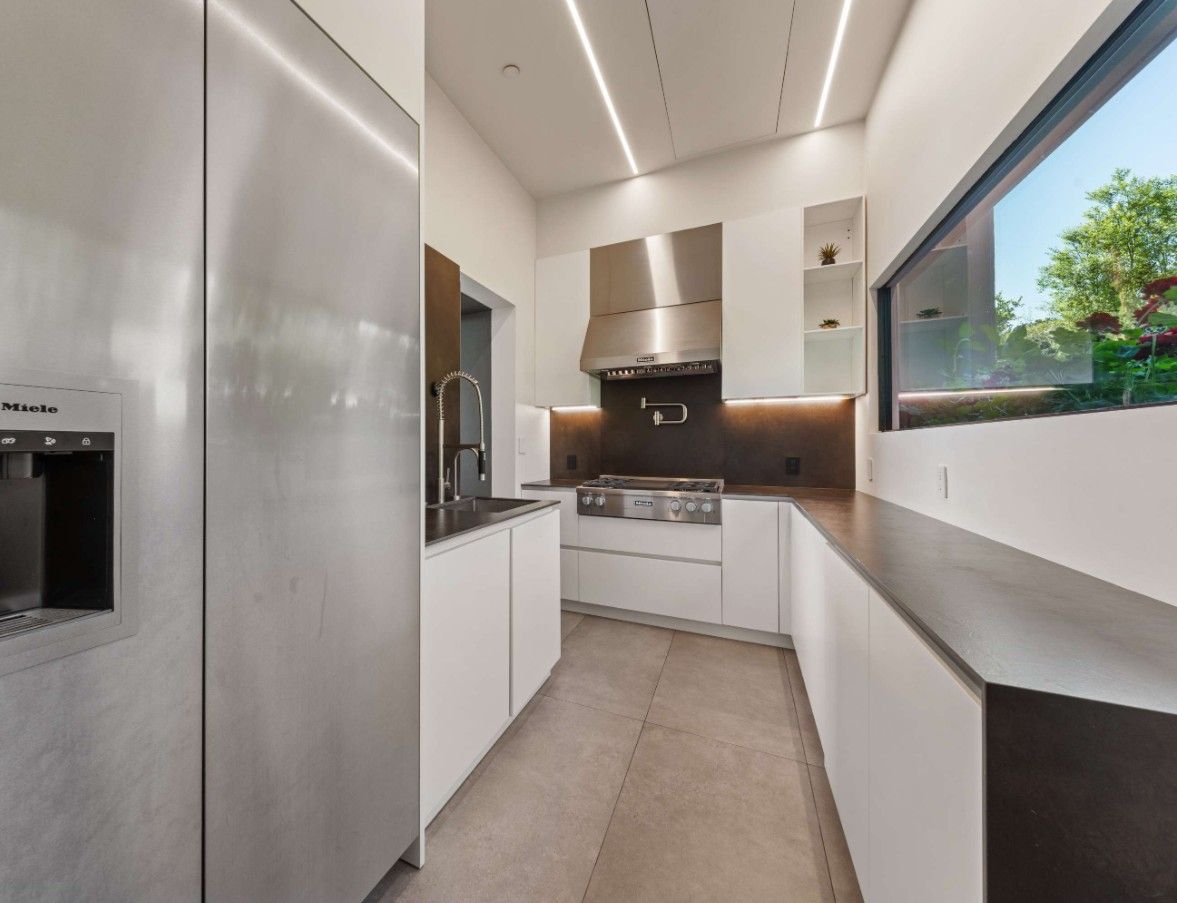 A kitchen with stainless steel appliances and white cabinets