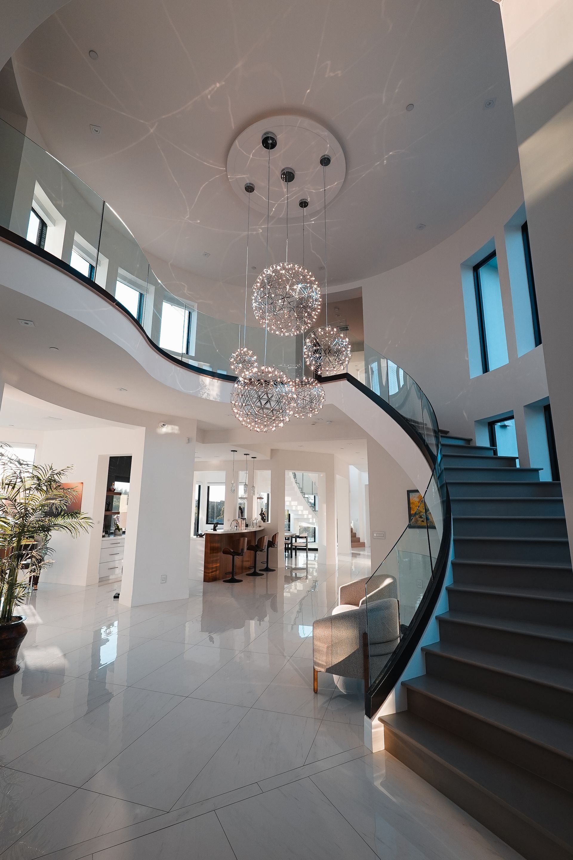 A large house with a spiral staircase and a chandelier hanging from the ceiling.