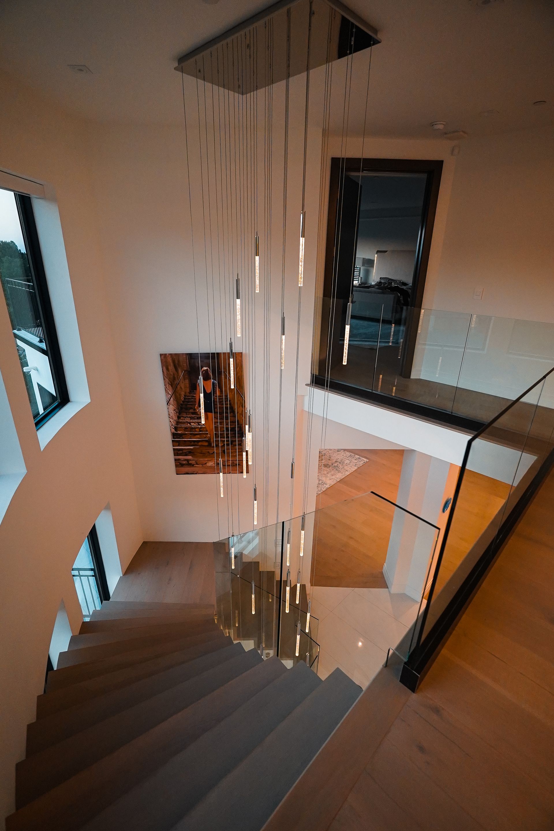 A staircase with a chandelier hanging from the ceiling