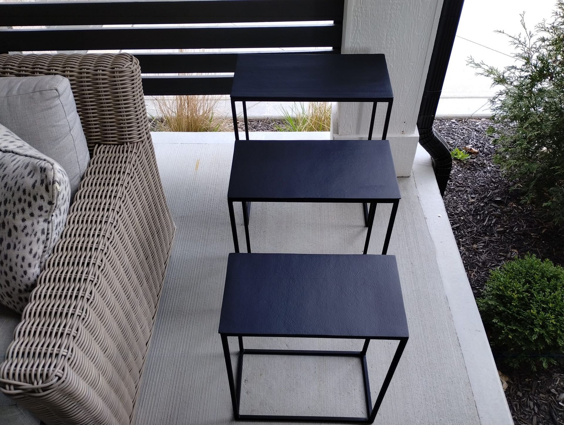 Built-in shelving unit with wood shelves and black metal supports above a countertop and cabinet.