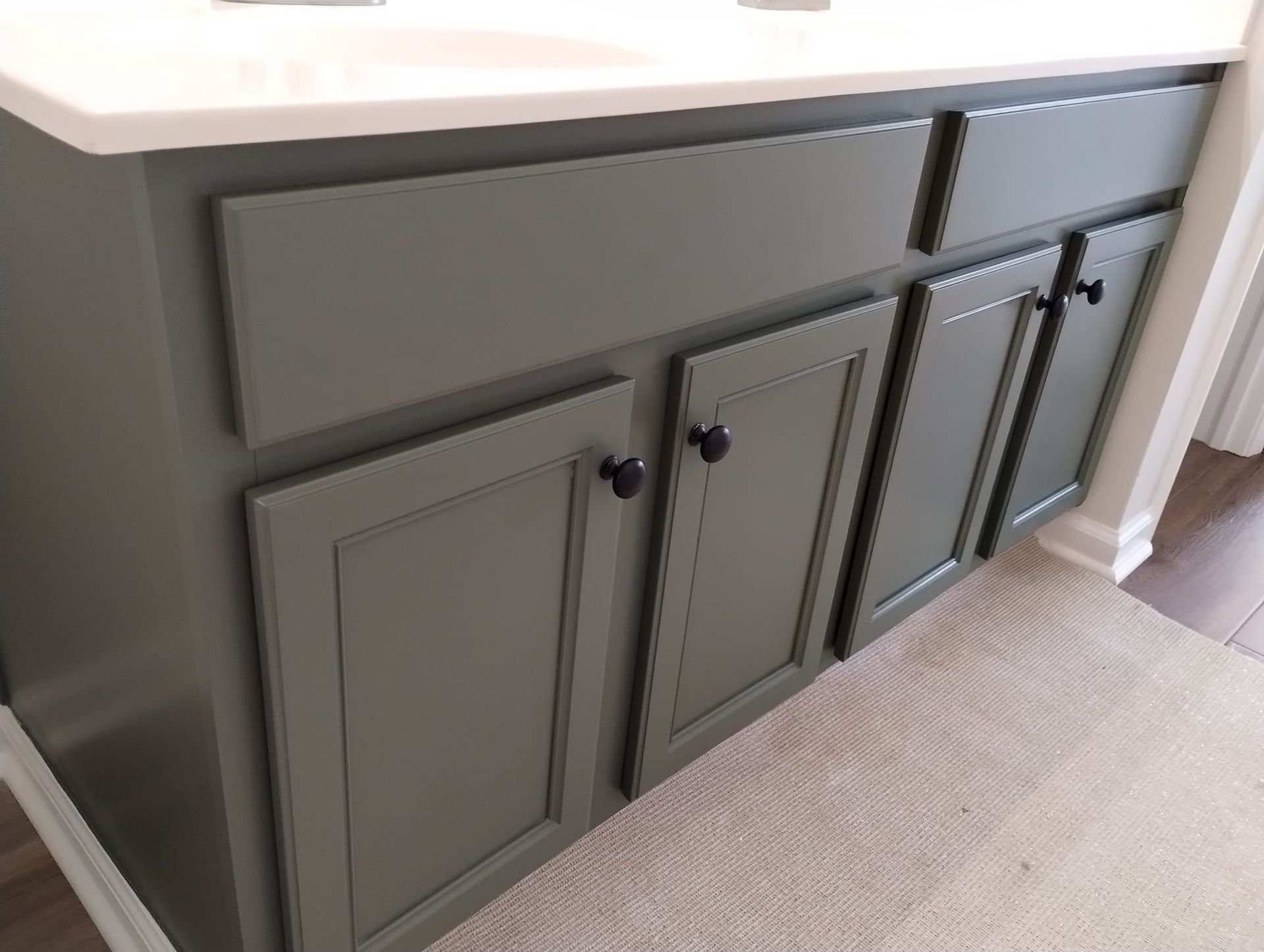 Kitchen with light-colored cabinets, gray countertops, a stove, and mosaic tile backsplash.
