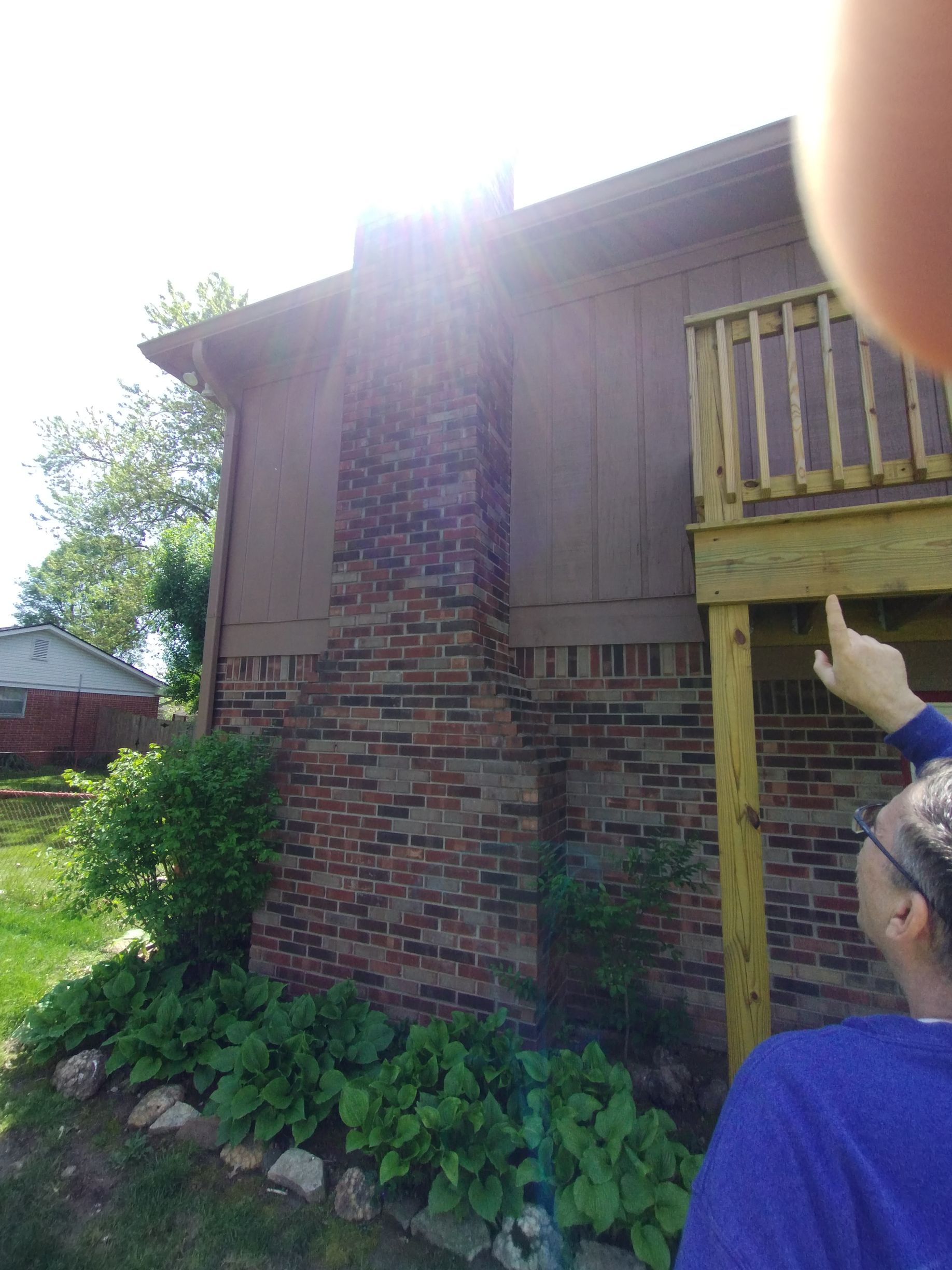 A white brick fireplace with a wooden mantle in a living room.
