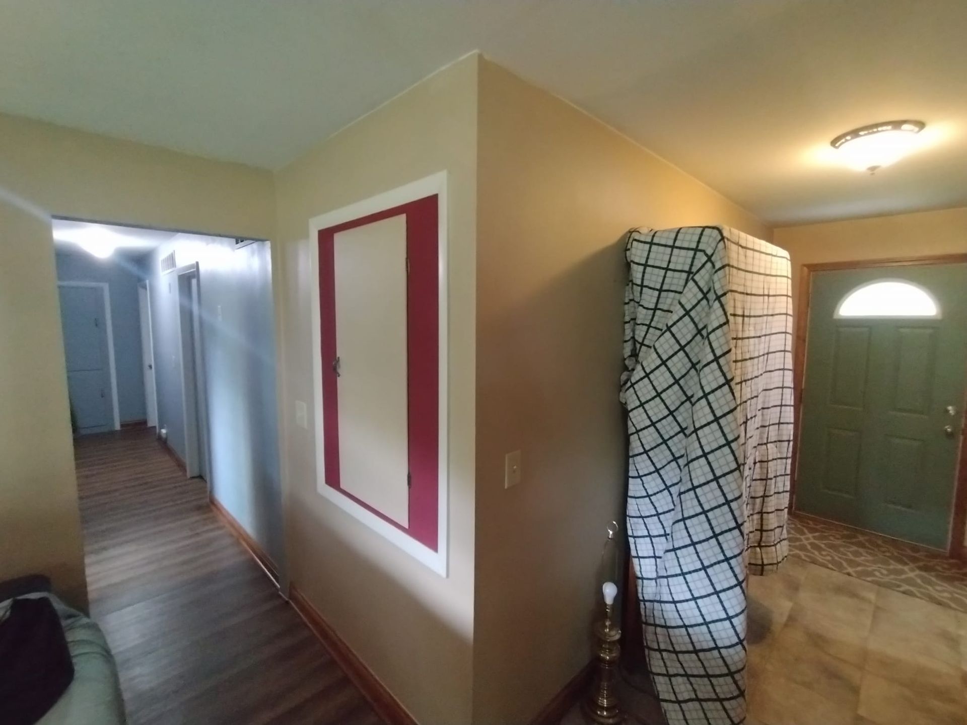 A hallway in a house with a mattress wrapped in plastic.